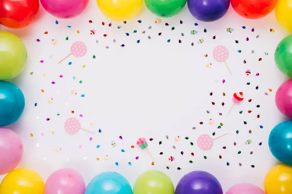 Palloncini colorati bordo con coriandoli puntelli sfondo bianco. Foto di alta qualità — Foto Stock