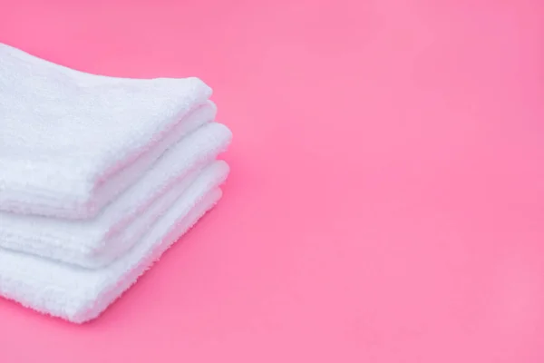 Pila toallas blancas fondo rosa. Foto de alta calidad — Foto de Stock