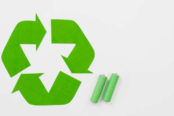Symbol recyklingu obok zielonych baterii. Wysokiej jakości zdjęcie — Zdjęcie stockowe