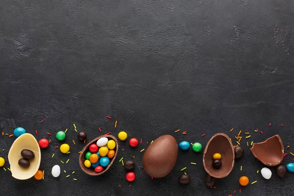 Vista superior ovos de Páscoa de chocolate preenchidos com doces coloridos. Foto de alta qualidade — Fotografia de Stock