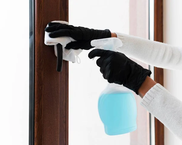 Manos con guantes desinfectando la manija de la ventana. Foto de alta calidad —  Fotos de Stock