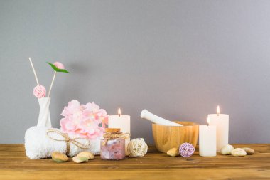 Aydınlatılmış mumlar şişeleri fırçala çiçek spa taşları havan topu ahşap masa üstü. Yüksek kalite fotoğraf