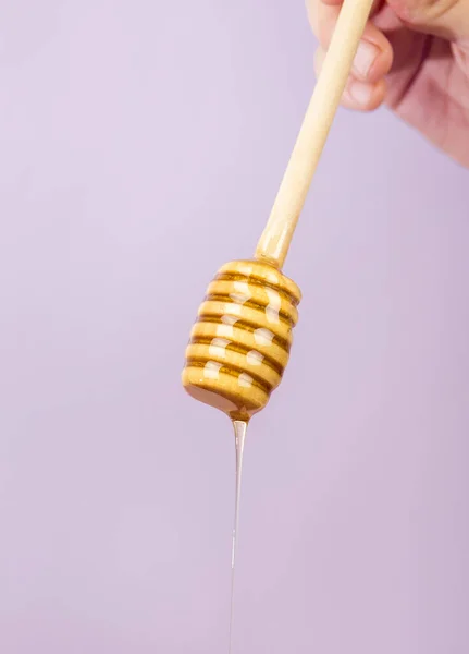 Mão humana segurando dipper com fundo roxo mel. Foto de alta qualidade — Fotografia de Stock