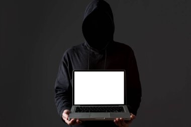 Öndeki erkek hacker dizüstü bilgisayar tutuyor. Yüksek kalite fotoğraf