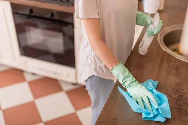 Vista laterale donna pulizia superficie della cucina. Foto di alta qualità — Foto Stock