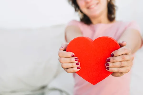 Gröda kvinna visar hjärtformade rutan. Högkvalitativt foto — Stockfoto