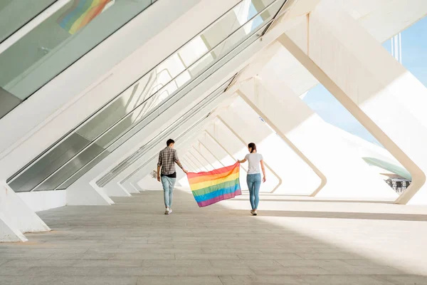 Lgbt pareja sosteniendo la bandera del arco iris. Foto de alta calidad — Foto de Stock