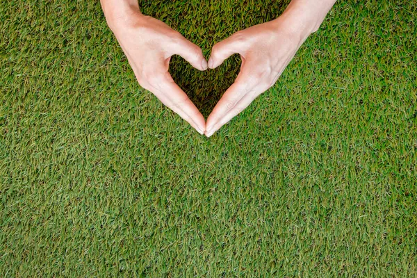 person making heart his hands grass. High quality photo