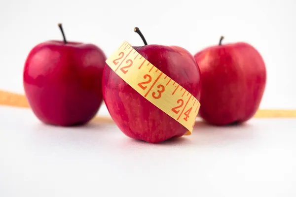 Tři jablka s odměrným páskovým stolem. Kvalitní fotografie — Stock fotografie