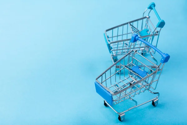 Carritos de compras fondo azul con espacio de copia. Foto de alta calidad — Foto de Stock