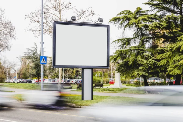 Véhicule flou passant par la route de panneau d'affichage vierge. Photo de haute qualité — Photo