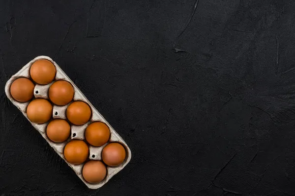 Коричневые куриные яйца вешалка черный стол. Высокое качество фото — стоковое фото