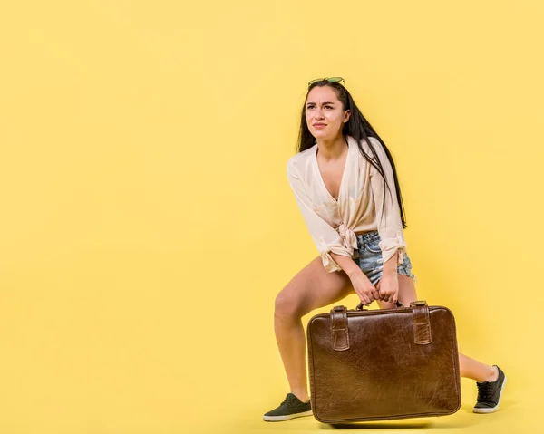 young female dragging vintage suitcase. High resolution photo