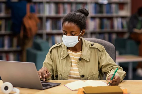student wearing face masks library. High resolution photo