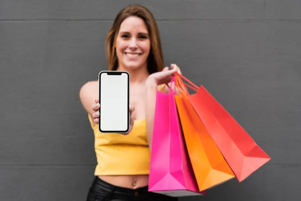 Chica Sonriente Con Bolsas Compras Sosteniendo Teléfono Foto Alta Resolución —  Fotos de Stock