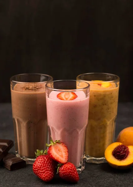 front view assortment milkshakes with chocolate fruits. High resolution photo