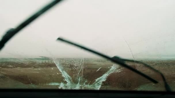 Η θέα από το μπροστινό παράθυρο του αυτοκινήτου με την εργασία υαλοκαθαριστήρες κατά τη διάρκεια του κρύου καιρού, ενώ κινείται. — Αρχείο Βίντεο