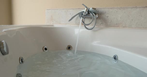 Jacuzzi vullen met water. Water stroomt uit de kraan, de badkamer is bijna vol. — Stockvideo