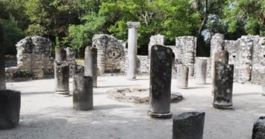 Arnavutluk 'un Butrint antik kenti. Çatısı olmayan sütunları olan bir salon, eski kalıntılar, açık bir gün, geniş çekim, yavaş çekim. Yüksek kalite 4k görüntü