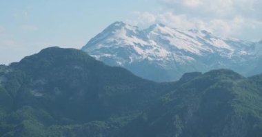 Alp dağları, karla kaplı tepeler, yeşil orman ve dağların genel manzarasına zum yap. Gündüz, bahar, Arnavutluk