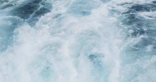 Blick vom Heck eines schnellen Schiffes auf das blaue Meerwasser, Wellen mit viel Schaum brechen auf, nachdem sich das Schiff bewegt hat. Nahaufnahme — Stockvideo