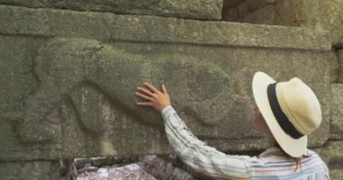 Genç kadın arkeolog, eski bir hayvan figürünü inceliyor. Butrint, Arnavutluk