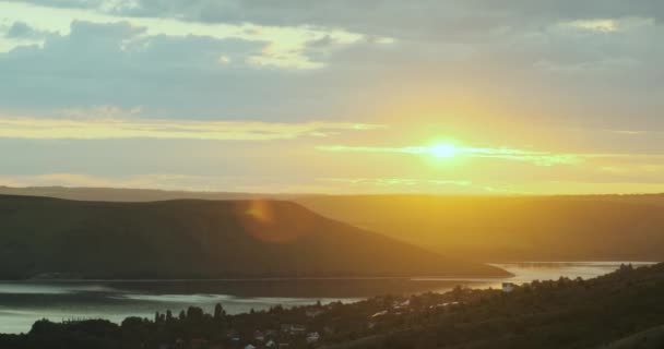 Panorama of orange sunset on the river among green high hills. Bakota, Ukraine, wide shot — стоковое видео