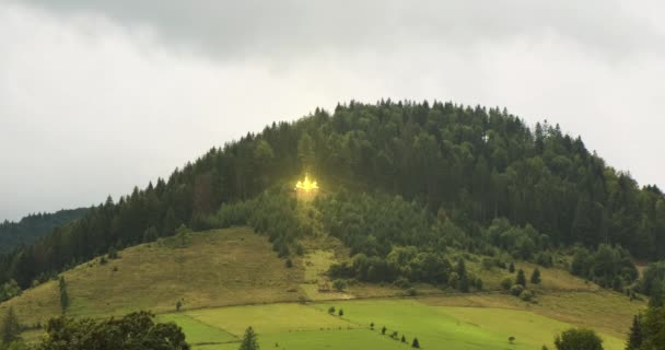 Soleil brillant sur les dômes jaunes de l'église, qui est situé sur le sommet de la colline au milieu de la forêt verte. Plan large, reflet du soleil. — Video