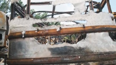 Irpin, April 2022, burnt in a shelled car in a parking lot. War in Ukraine, cutting frames of broken cars. 