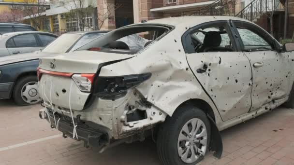 Irpin, Ουκρανία, Απρίλιος 2022. Κατεστραμμένο αυτοκίνητο αφού χτυπήθηκε από θραύσματα κελύφους. Συνέπειες του πολέμου με τη Ρωσία. — Αρχείο Βίντεο