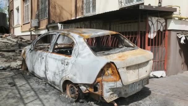 Irpin, Ucrania, abril de 2022. Un coche quemado cerca de la casa, después de ser golpeado por fragmentos de concha. Consecuencias de la guerra con Rusia. — Vídeo de stock