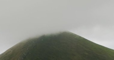 the top of the mountain covered with a gray cloud. Fog movement along Hoverla, Carpathians, Ukraine.