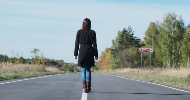 Una Ragazza Con Mantello Nero Lontananza Lungo Segni Bianchi Del — Video Stock