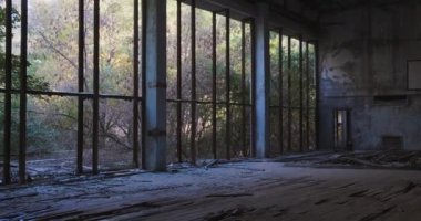 Pripyat 'ın uzak bölgesindeki spor salonunda terk edilmiş ve yok edilmiş. Çernobil faciası, hayalet şehir. Koridorun kırık pencerelerinin arkasındaki ağaçlar. Yüksek kalite 4k görüntü