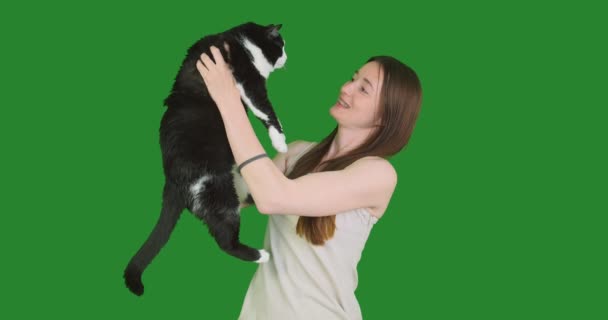 少女は猫を手に持っている 彼女のペット 笑顔と笑い ペットの愛 脂肪猫が大好きです 緑の背景 クロマキー 肖像画 クローズアップ 高品質4K映像 — ストック動画