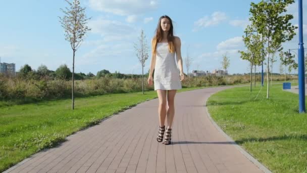 Αυτοπεποίθηση Γυναίκα Ένα Λευκό Φόρεμα Περπατά Προς Την Κάμερα Πλάκες — Αρχείο Βίντεο
