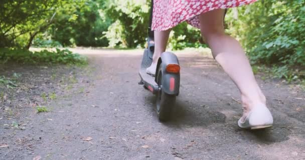 Kvinnan Klänning Börjar Röra Sig Elektrisk Skoter Längs Vägen Parken — Stockvideo