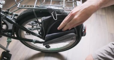 Erkekler aletleri, pompayı, katlanan bıçağı, tamir setini bisiklet çantasına koyar. Yolculuk için hazırlıklar, seyahat. Yakın plan, kapalı mekan. Yüksek kalite 4k görüntü