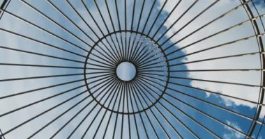 Büyük kuş kafesi, kamera yukarı bakıyor ve hareket ediyor. Bulutlu mavi gökyüzü, güneş, gündüz. Yüksek kalite 4k görüntü