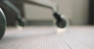 Ofis sandalyesi yerde yuvarlanıyor. Silikon sessiz tekerleklere yakın çekim. Yan görüş. Yüksek kalite 4k görüntü