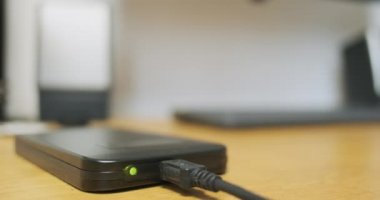 Blinking indicator light during external hard drive operation, data exchange, close-up. HDD lies on desktop, indication of work. High quality 4k footage