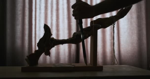 Силуэт Грызущей Ножки Хамона Деревянном Подставке Руки Длинными Ножами Вырезающими — стоковое видео