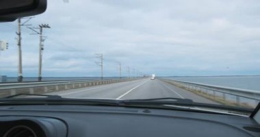 Arabanın ön camından bak, baraj boyunca baraj boyunca git. Bulutlu, yol uzaklaşıyor. Seyahat, tatil konsepti. Yüksek kalite 4k görüntü