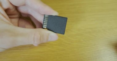 SD adaptörüne mikro SD bellek kartı ekle. Yakından, erkek eli adaptöre küçük bir hafıza kartı yerleştirir. Yüksek kalite 4k görüntü
