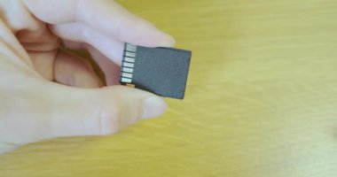 SD adaptörüne mikro SD bellek kartı ekle. Yakından, erkek eli adaptöre küçük bir hafıza kartı yerleştirir. Yüksek kalite 4k görüntü