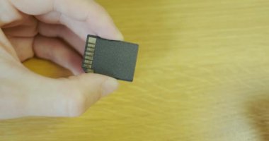 SD adaptörüne mikro SD bellek kartı ekle. Yakından, erkek eli adaptöre küçük bir hafıza kartı yerleştirir. Yüksek kalite 4k görüntü