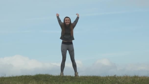 Young Long Haired Woman Sports Uniform Jumps Green Hill Beautiful — Vídeos de Stock
