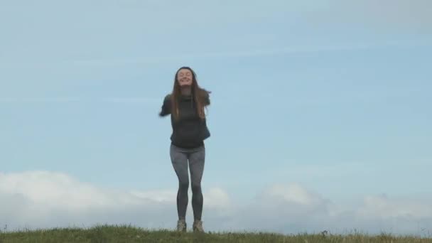 Young Long Haired Woman Sports Uniform Jumps Green Hill Beautiful — Vídeos de Stock