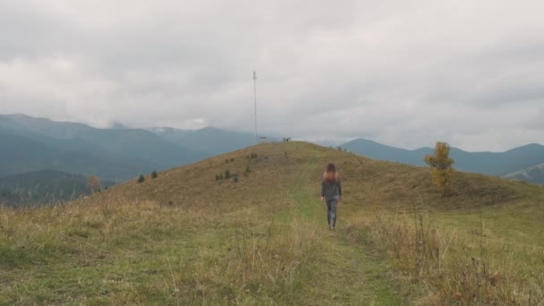 Young Woman Walks Green Mountain Range Mobile Tower Daytime Mountains — 图库视频影像