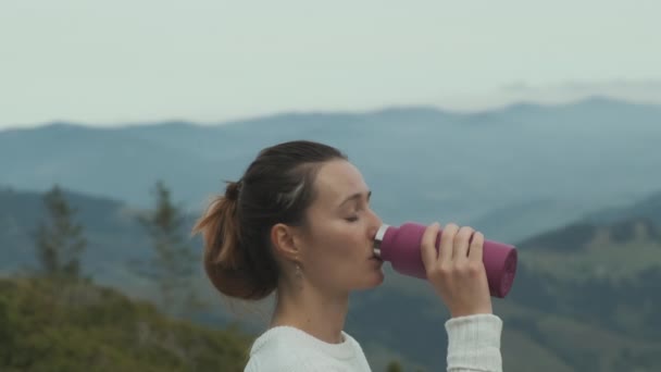 Kobieta Swetrze Pije Wodę Różowej Kolby Tle Gór Chmur Nieba — Wideo stockowe